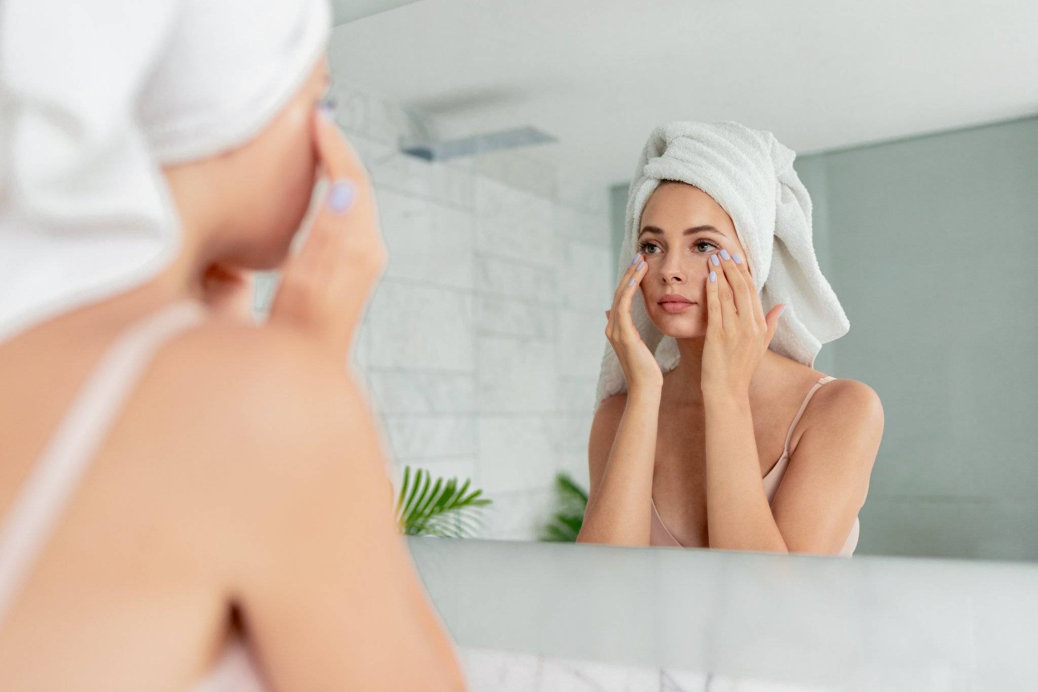 girl checking skin in mirror