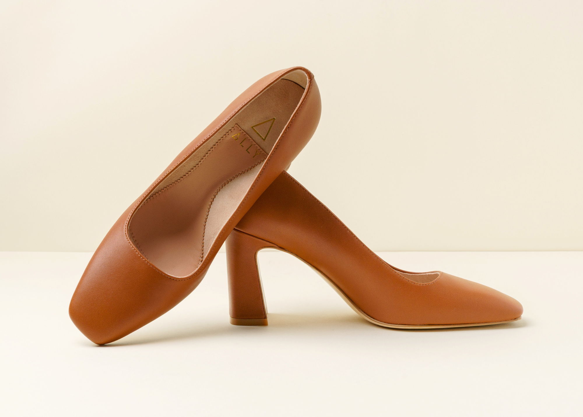 Brown high-heeled shoes on a neutral background.