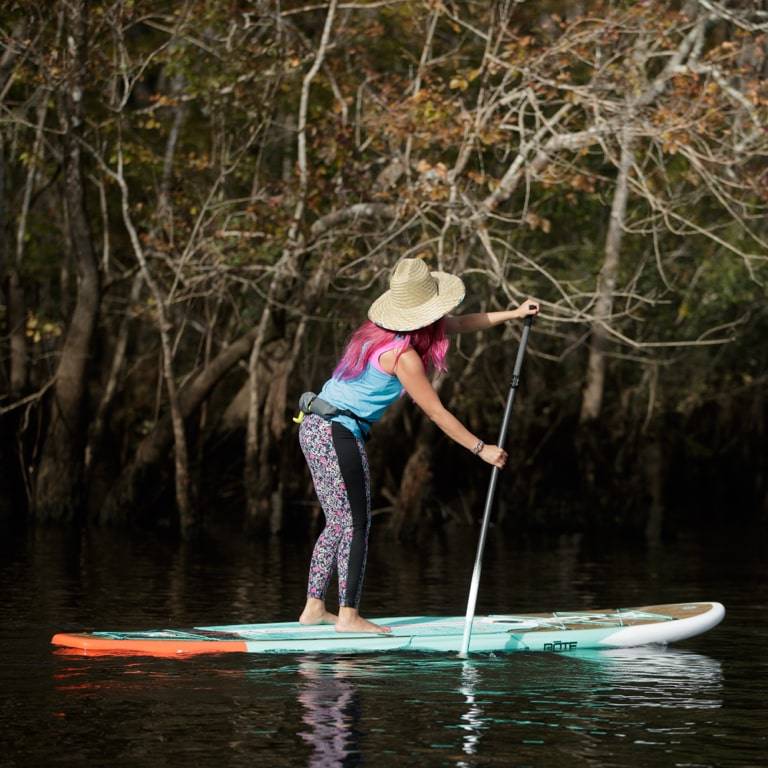 Woman paddling her Flood 10′6″ Classic Teak Paddle Board