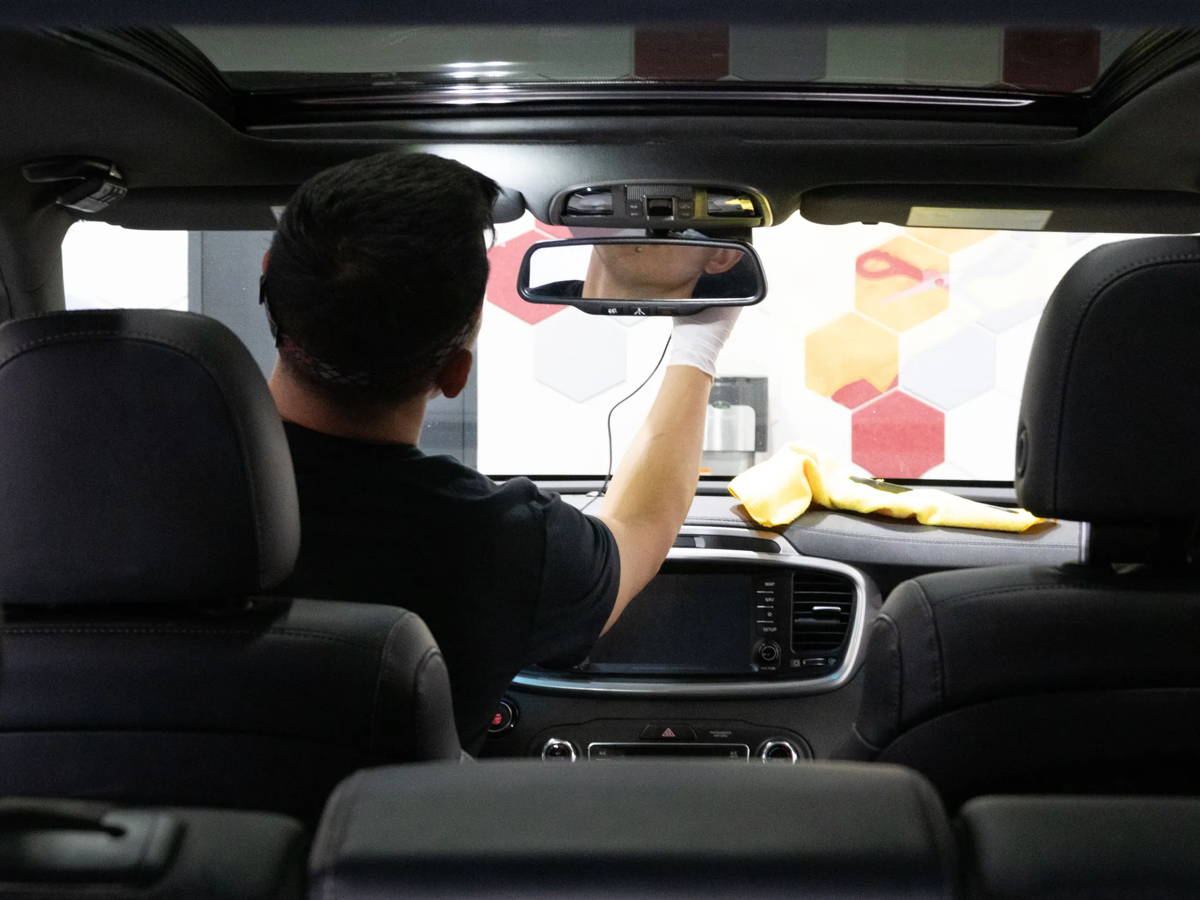 Technician positioning a dash cam inside a vehicle