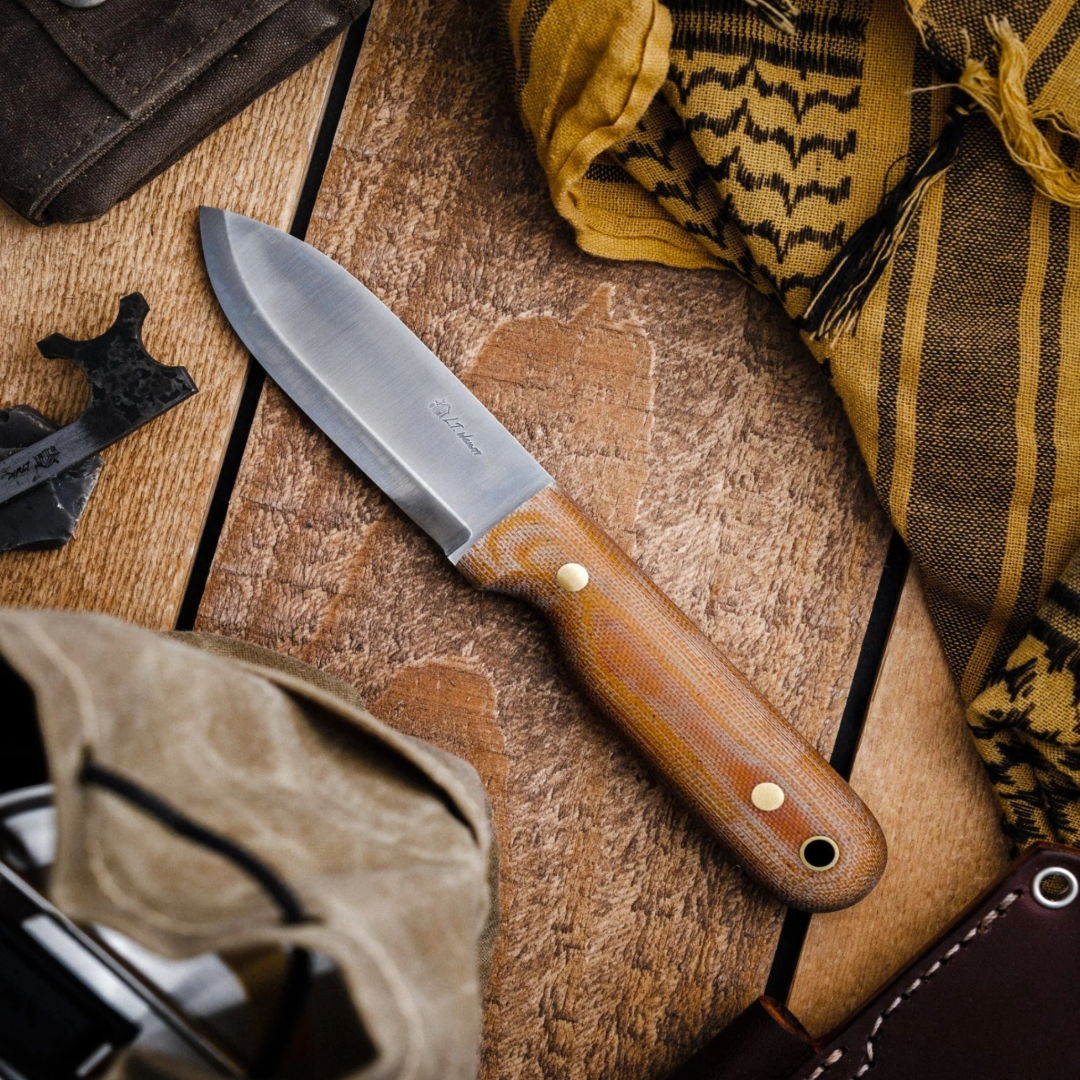 A wooden-handled knife on a rustic wooden surface surrounded by various items.