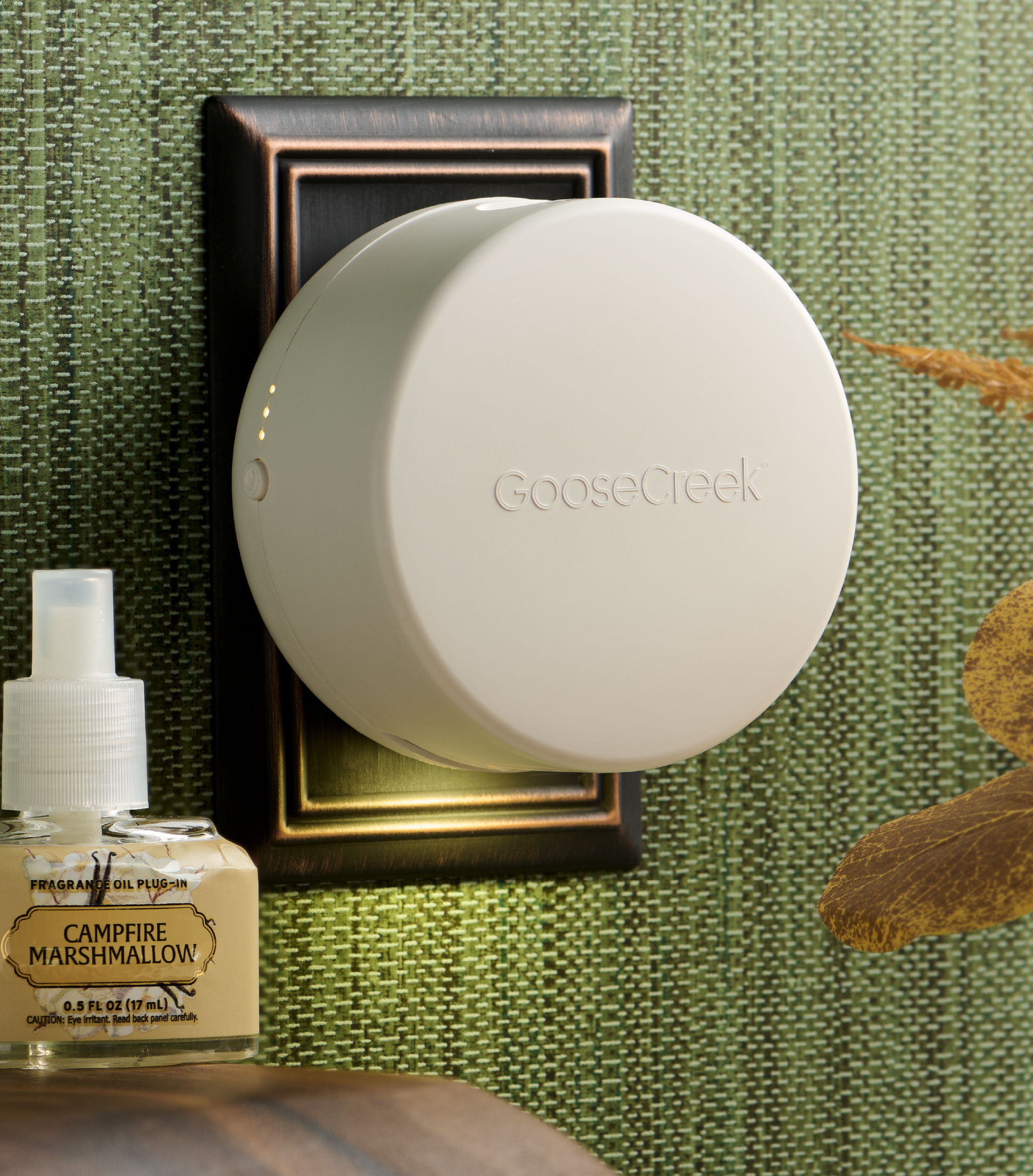A white circular device mounted on a wall, next to a perfume bottle.