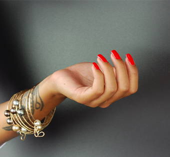 hand with mandarin non toxic nail polish on black background
