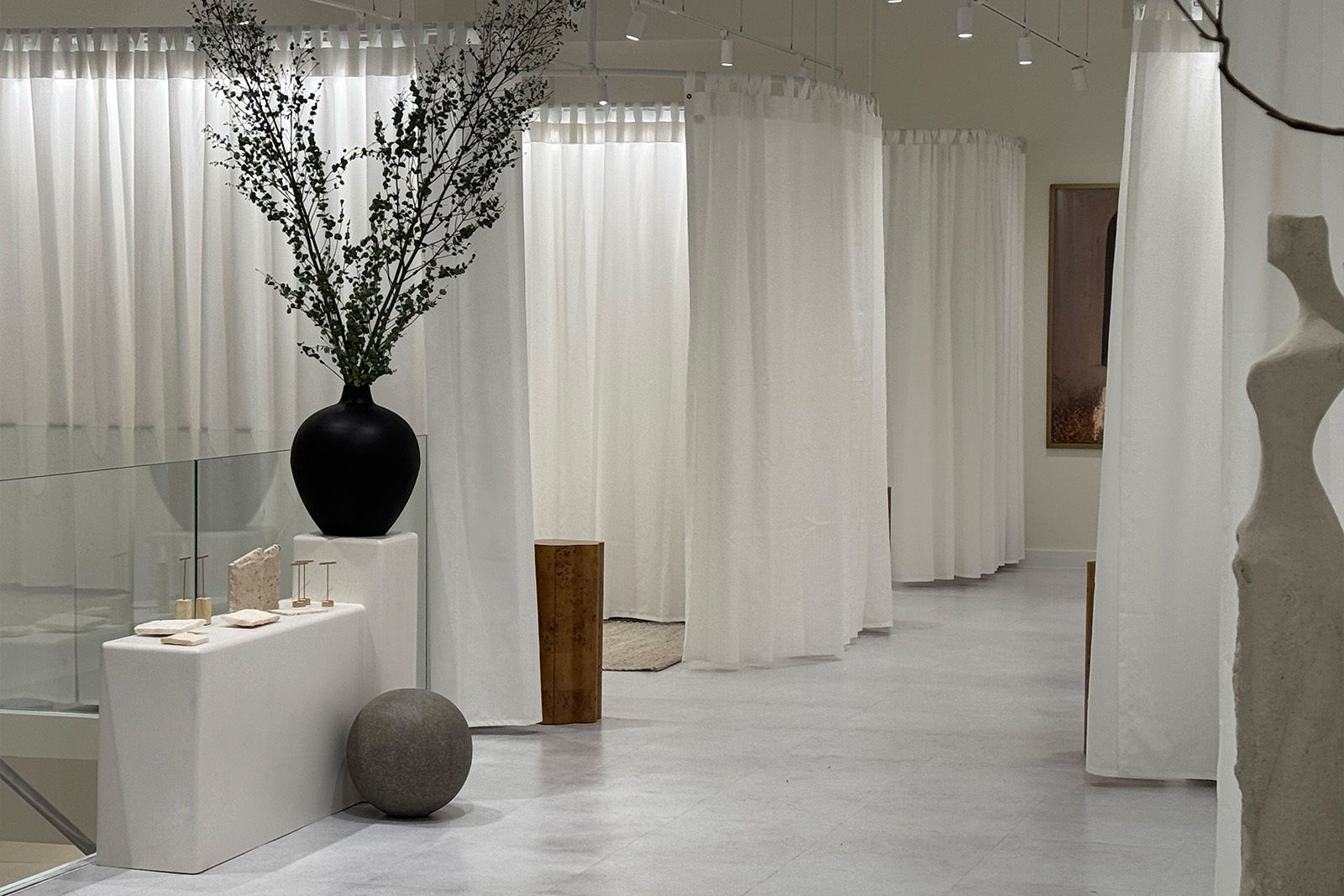 Interior of a modern space with white curtains and decorative plants.