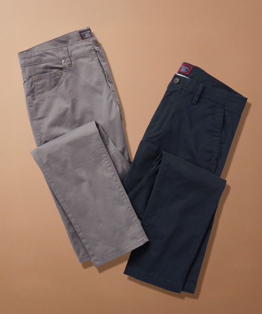 Two pairs of pants, one gray and one navy, on a beige background.