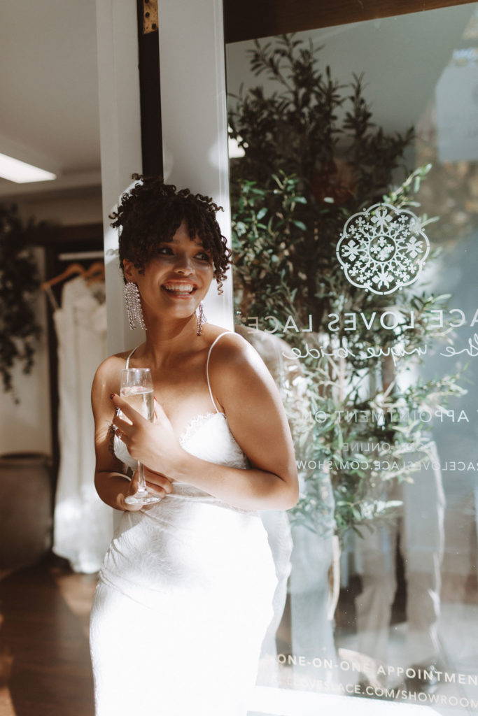 Femme portant une robe de mariée à fines bretelles à la boutique de mariage Grace Loves Lace.