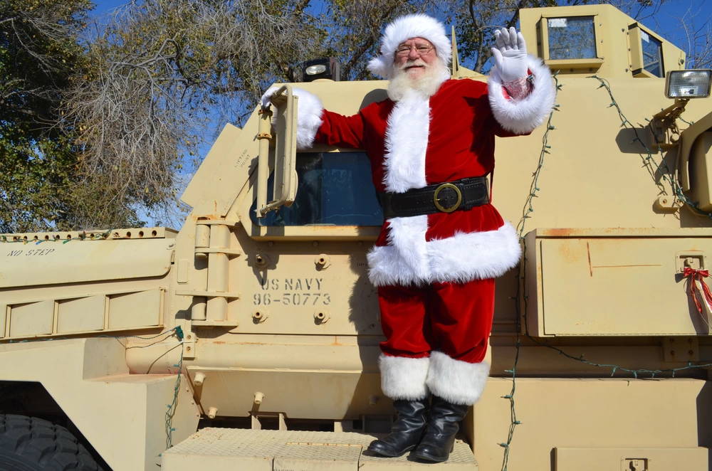Santa climbs on board a joint EOD rapid response vehicle (JERRV) for the Explosive Ordnance Disposal Group One Children's Christmas Party held on board Naval Amphibious Base Coronado. (U.S. Navy photo by Lieutenant Commander Donnell Evans/Released)