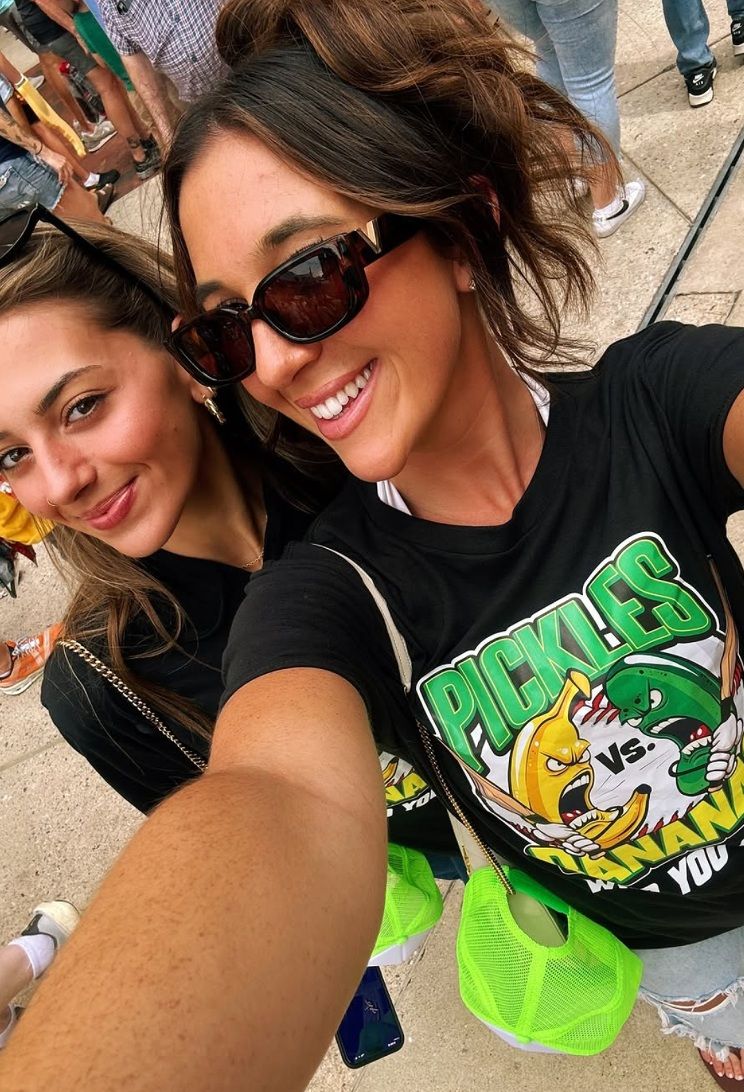 Krystn and Chiara, two sisters and longtime The Big Dill® attendees, in custom Pickles vs. Bananas shirts at Camden Yards in Baltimore
