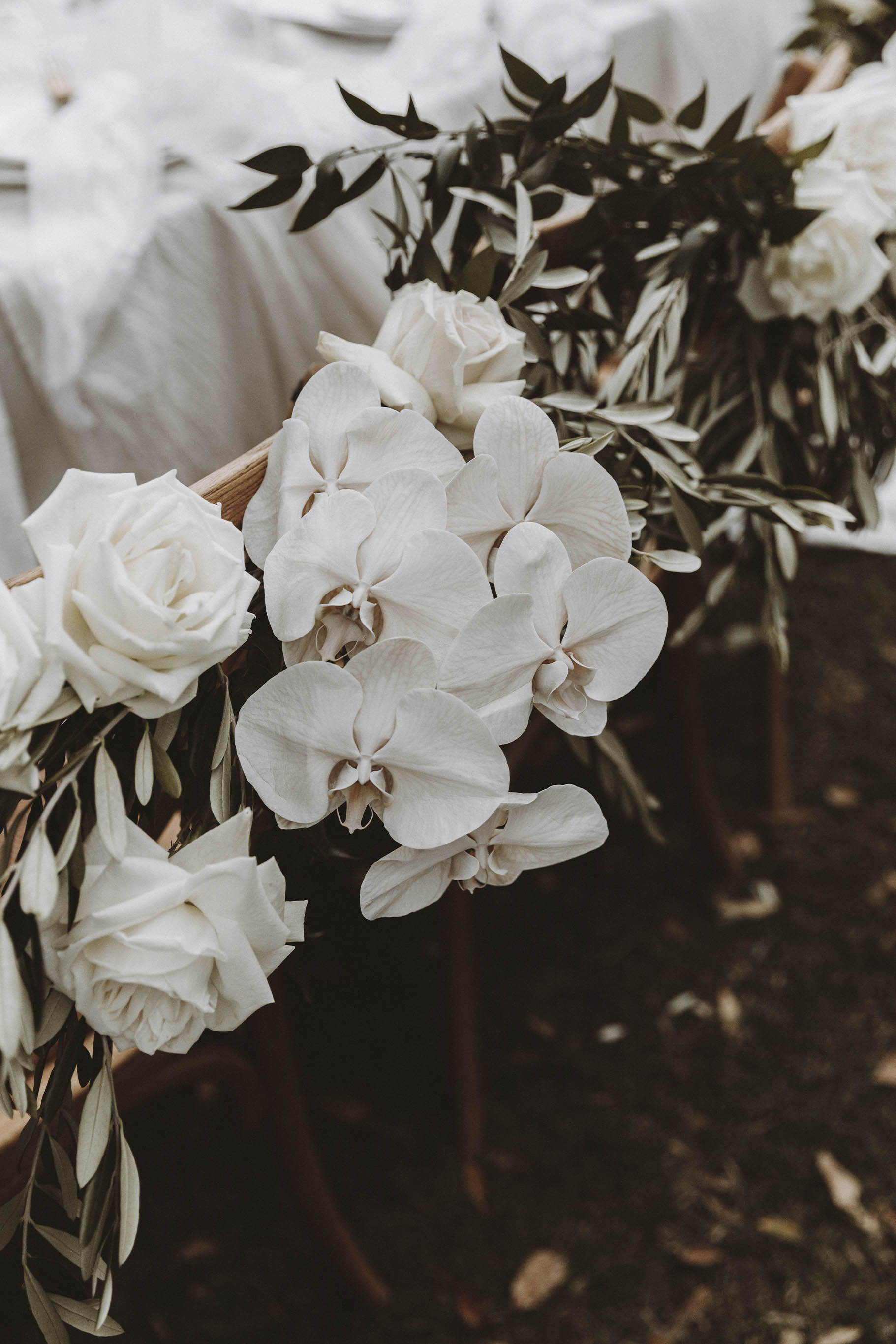 Arrangement floral blanc sur le dossier des sièges en bois