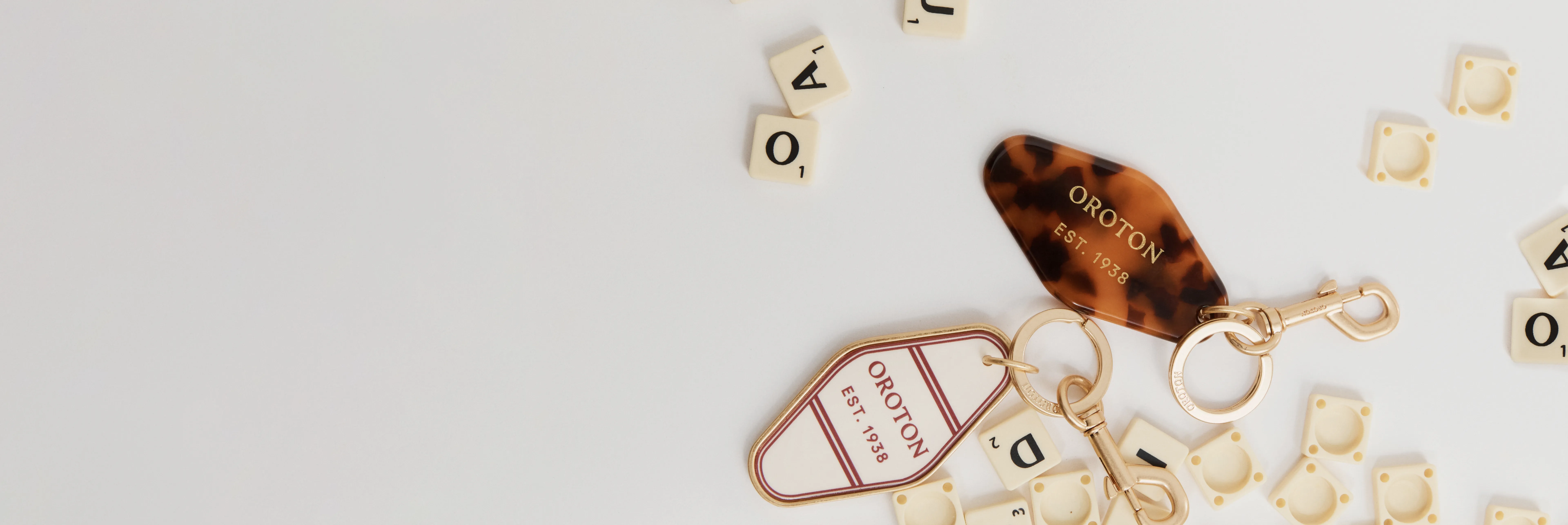 Scattered letters and a tortoiseshell hair accessory on a white background.