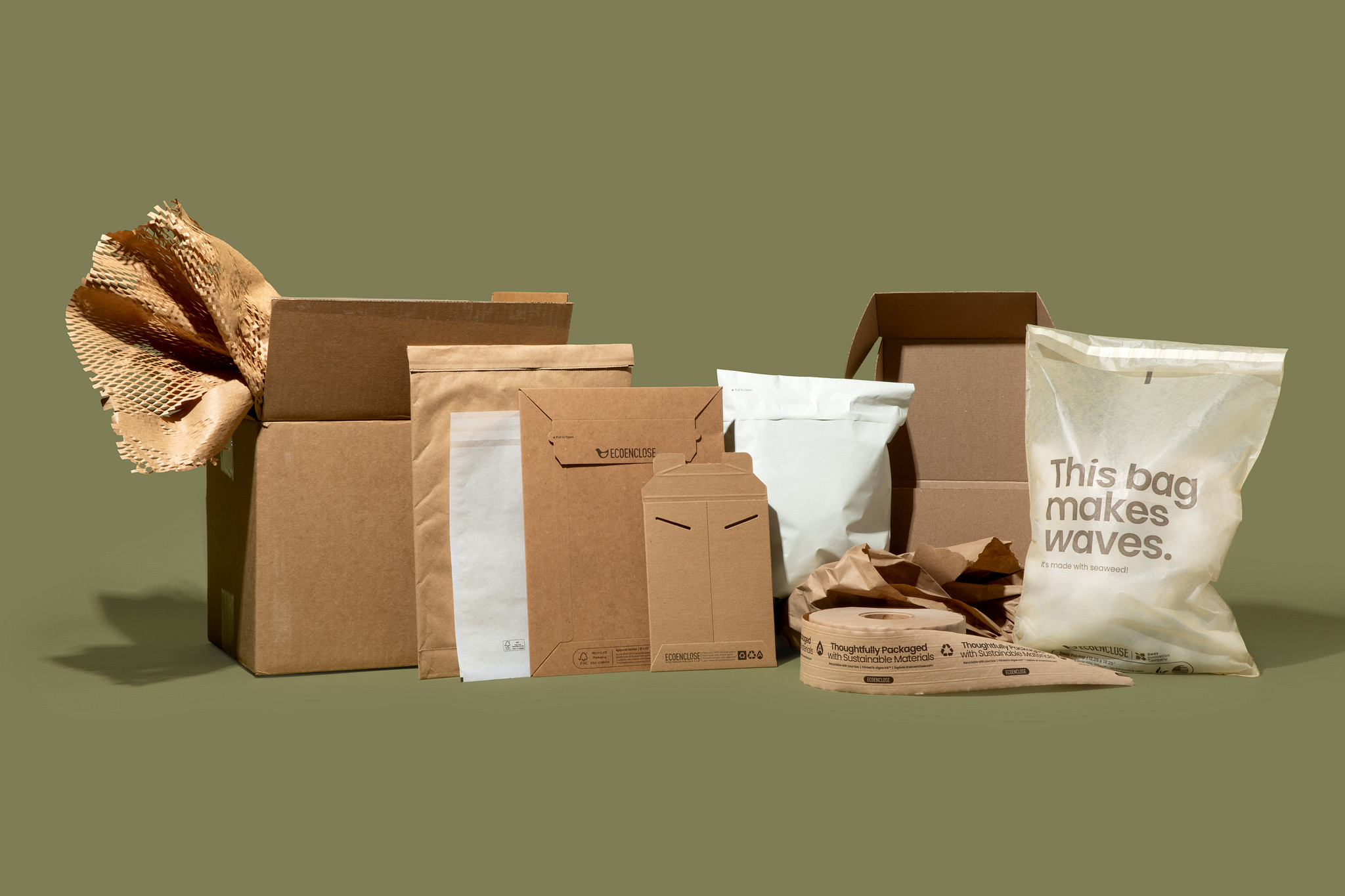 Assorted cardboard boxes and paper packaging on a green background.