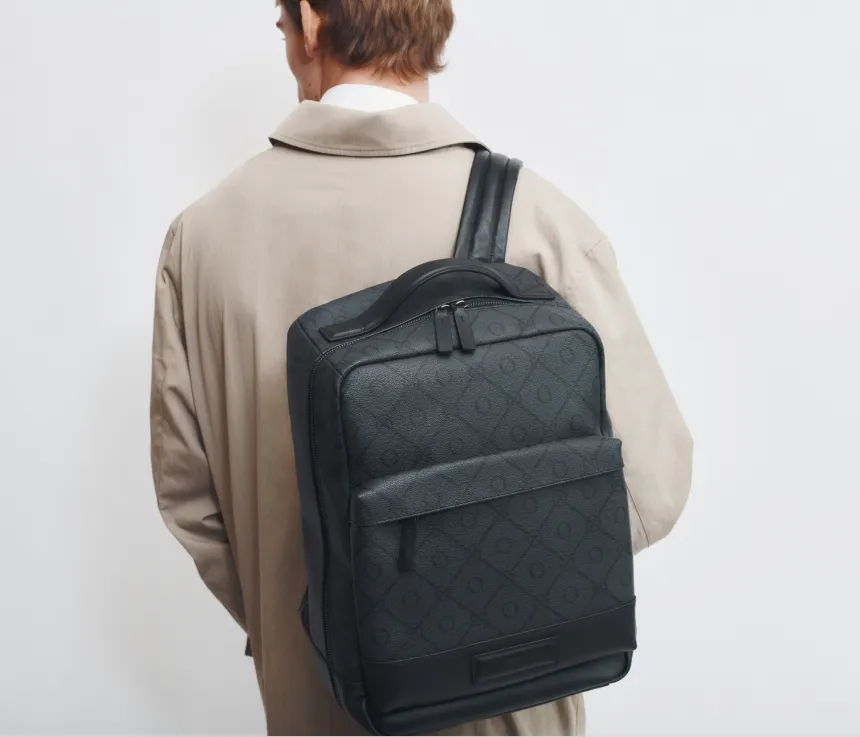 Person wearing a coat, carrying a black backpack, viewed from behind.