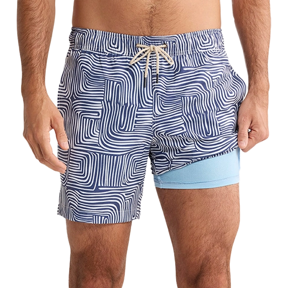 A man wearing swim trunks with a blue and white pattern.