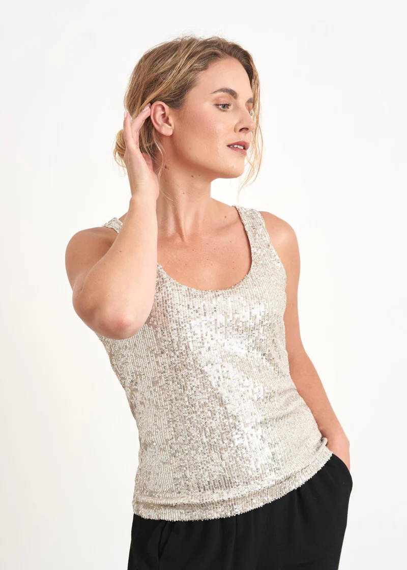 A model wearing a champagne gold sleeveless top covered in sequins