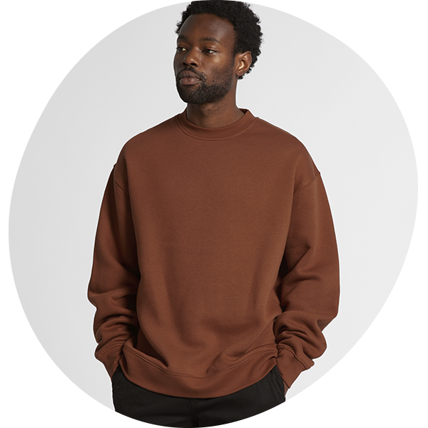 Model wearing a rust brown relaxed-fit crewneck sweatshirt