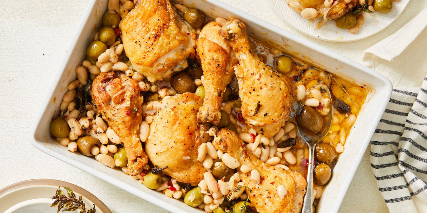 Roasted chicken in a baking dish with cannellini beans and green olives