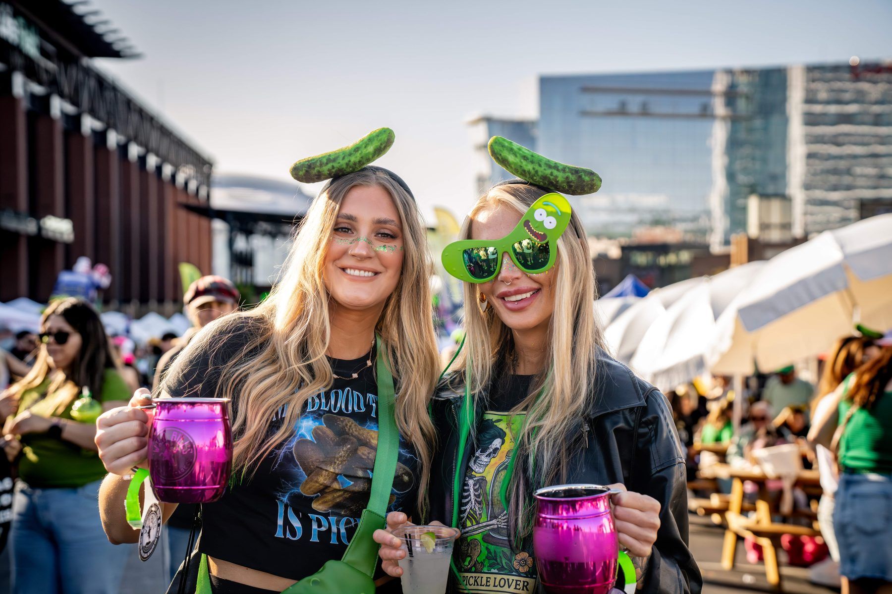 Two VIP guests in pickle headbands and novelty pickle sunglasses with custom barrel mugs at The Big Dill Arlington Texas 2025.