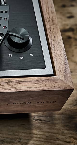Close-up of a turntable plinth with controls and branding.