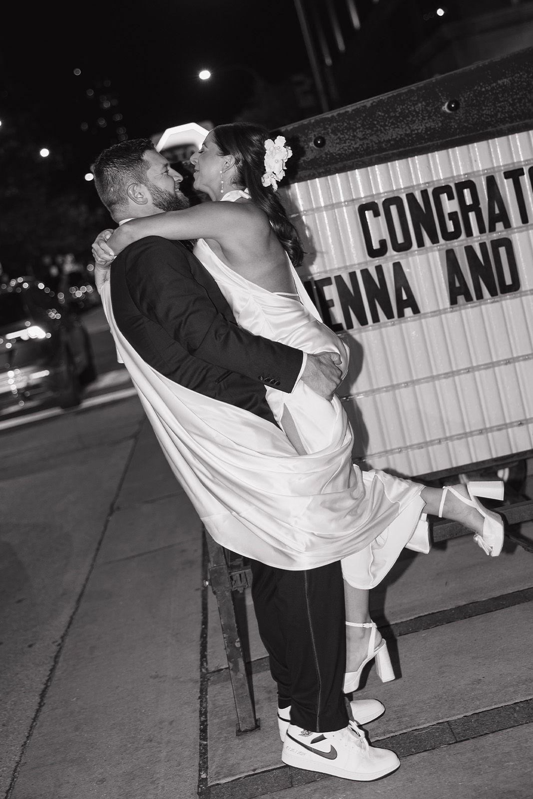Couple celebrating wedding, bride in wedding dress, joyful embrace.