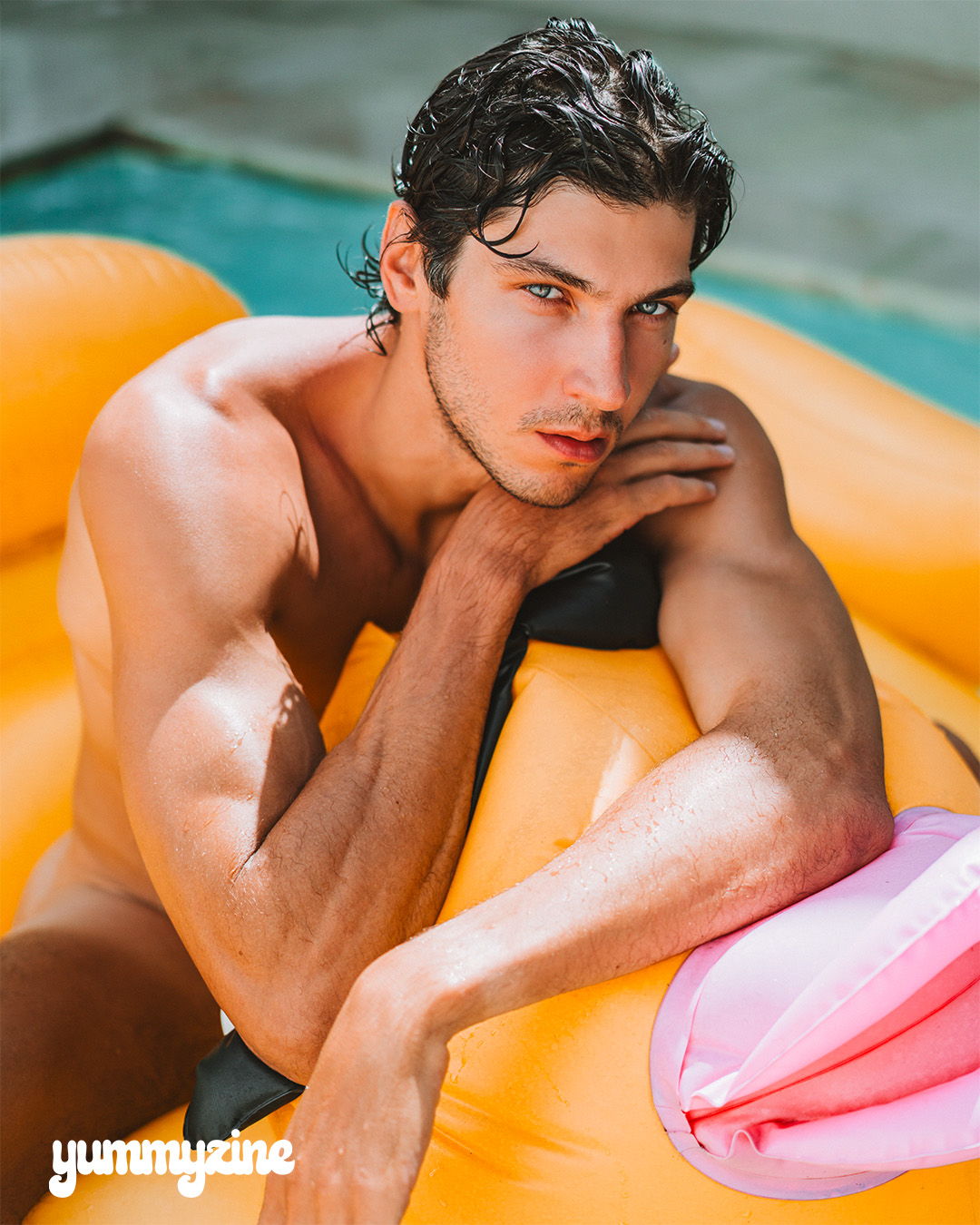 Young man lounging on a float in a pool.