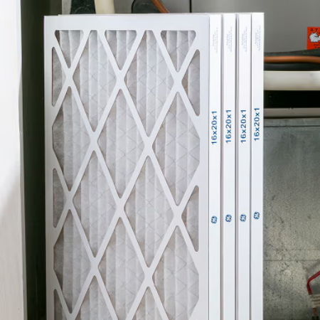 Four air filters stacked vertically against a wall.