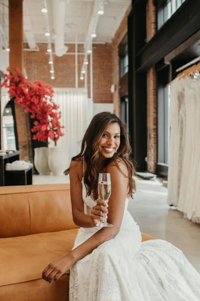 Bride sipping champagne at the Boston Grace Loves Lace showroom