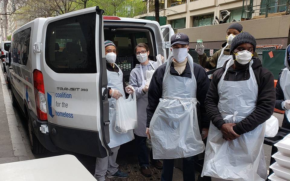 Volunteers wearing masks and aprons supporting Coalition For the Homeless
