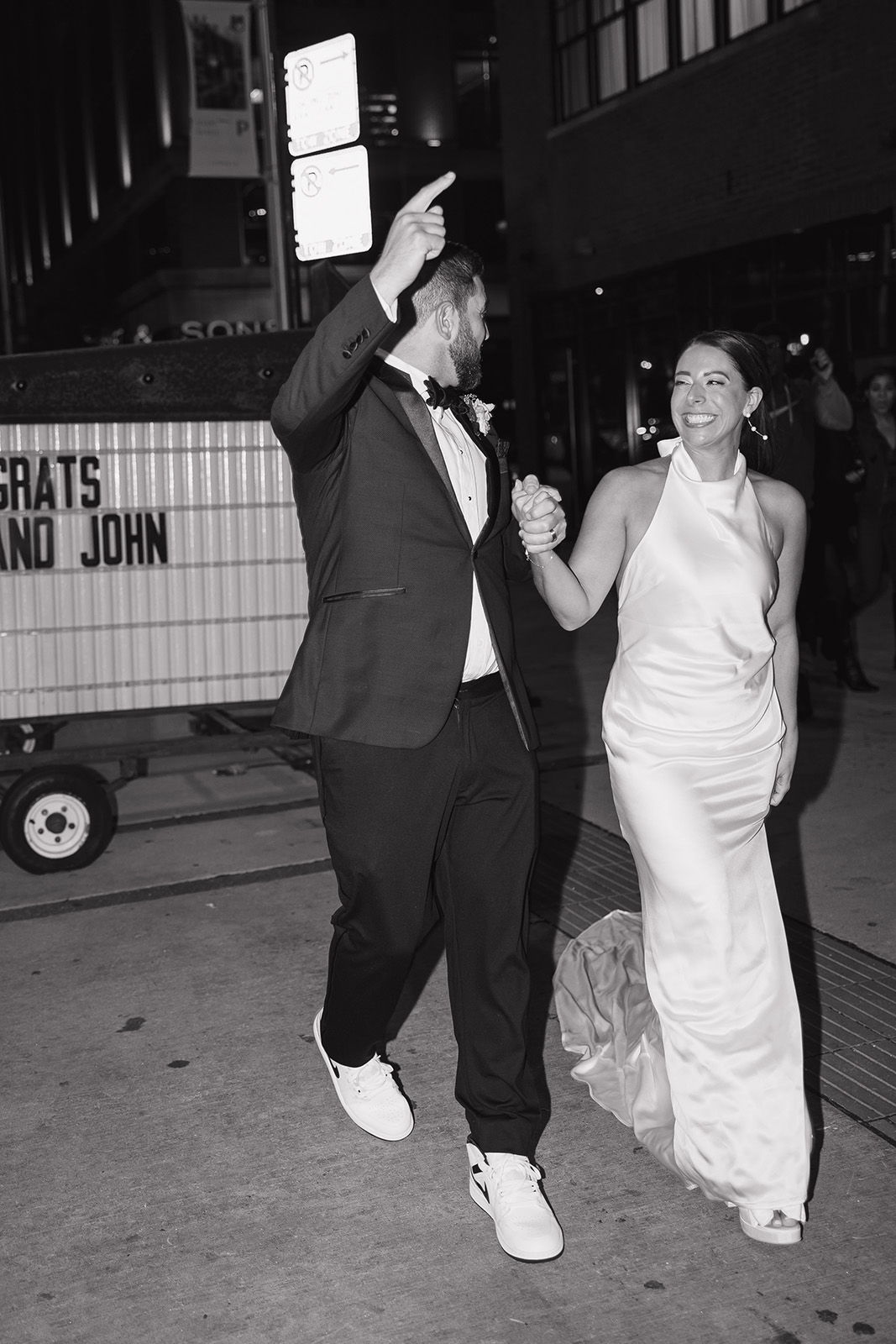 Couple joyfully walking together in wedding attire.