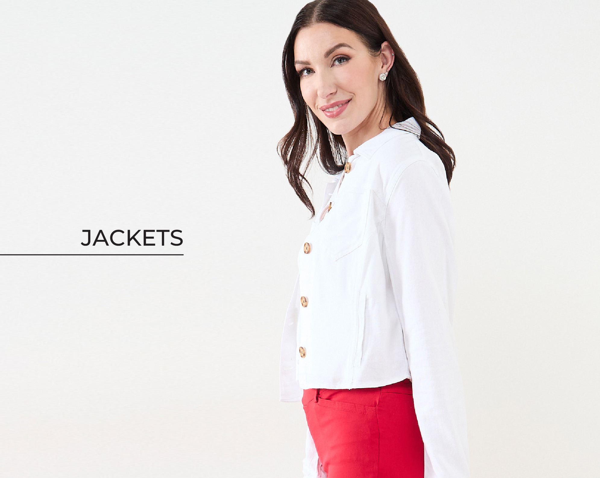 A woman smiling, wearing a white jacket and red pants.