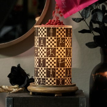 A decorative lamp with patterned design and scattered red items on top.