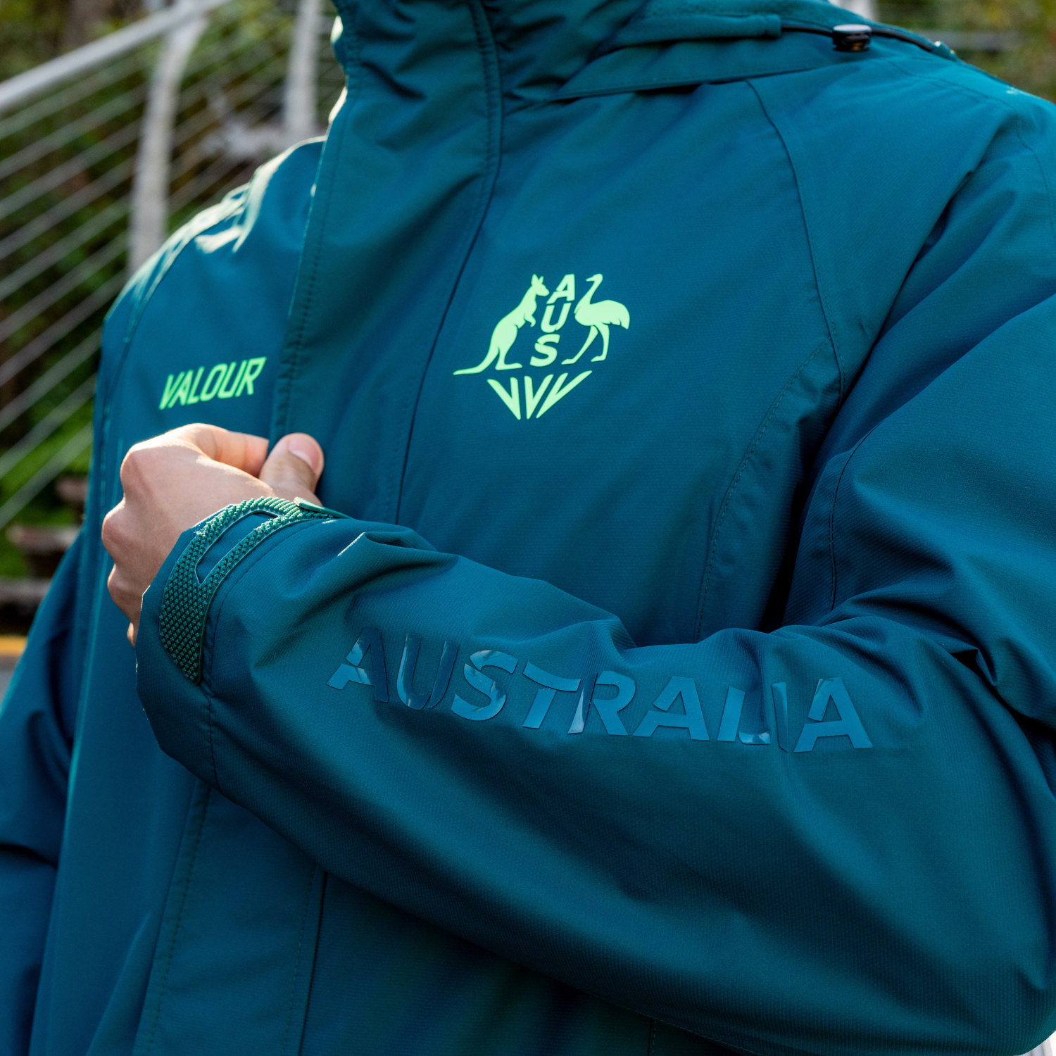 A person wearing a teal jacket with 