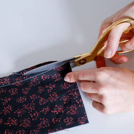 Cutting dark fabric with golden fabric shears