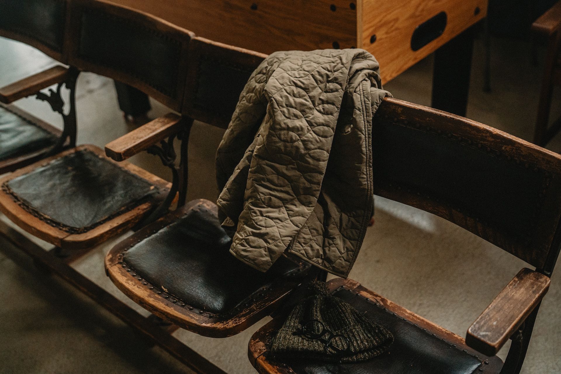 A coat draped over wooden chairs in a casual setting.