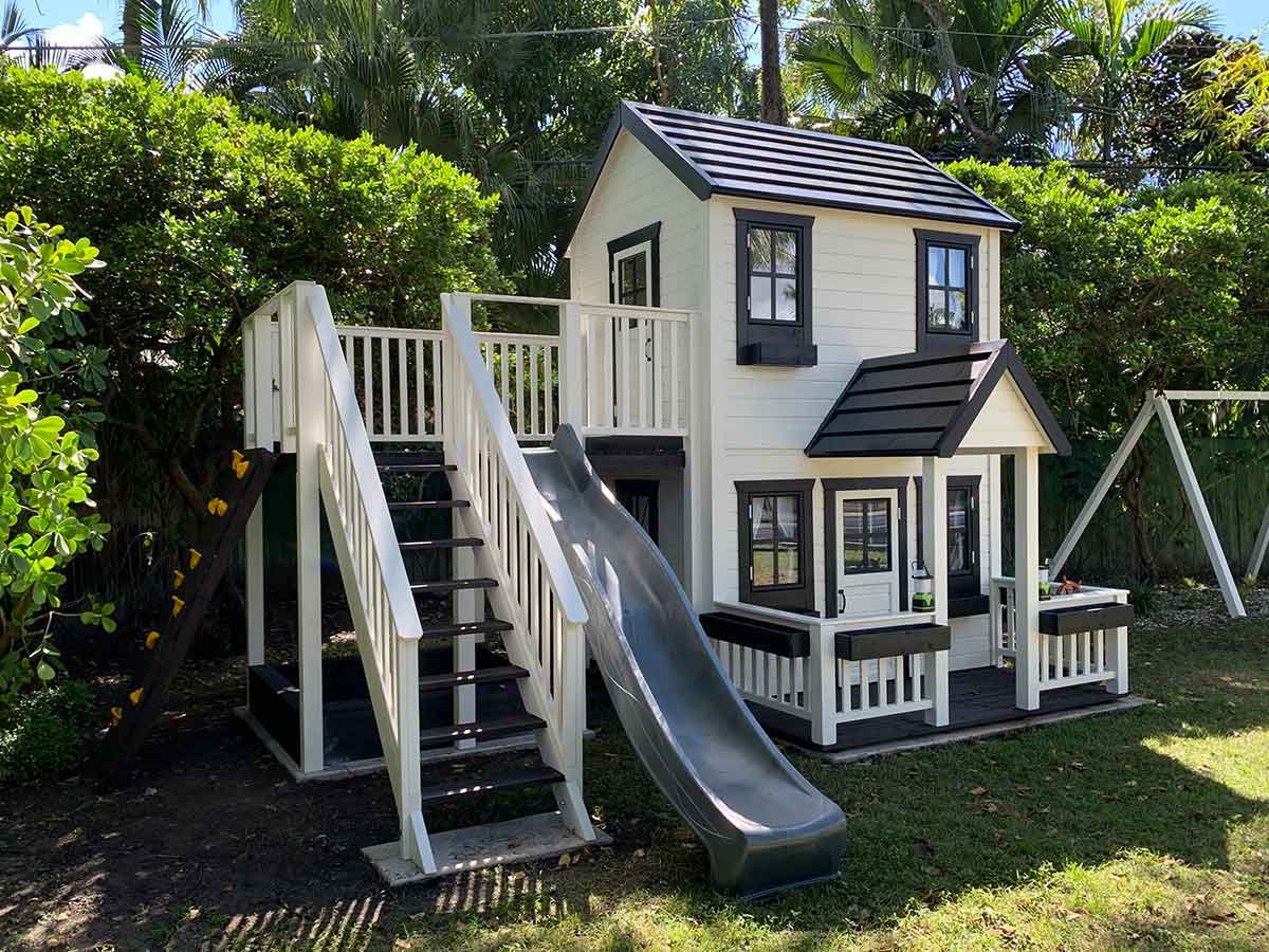 2- story Wooden Playhouse with gray slide, wooden terrace and flower boxes by WholeWoodPlayhouses