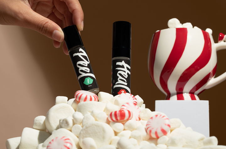 Hand placing items on a pile of marshmallows and peppermint candies.