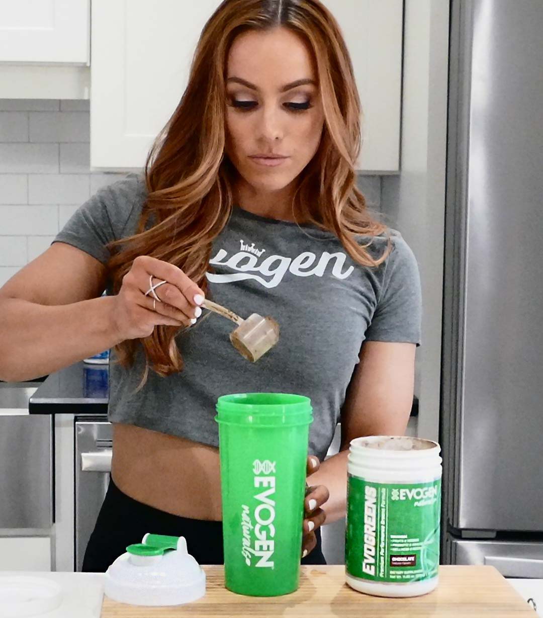 Athlete scooping Evogreens Chocolate into a shaker in the kitchen