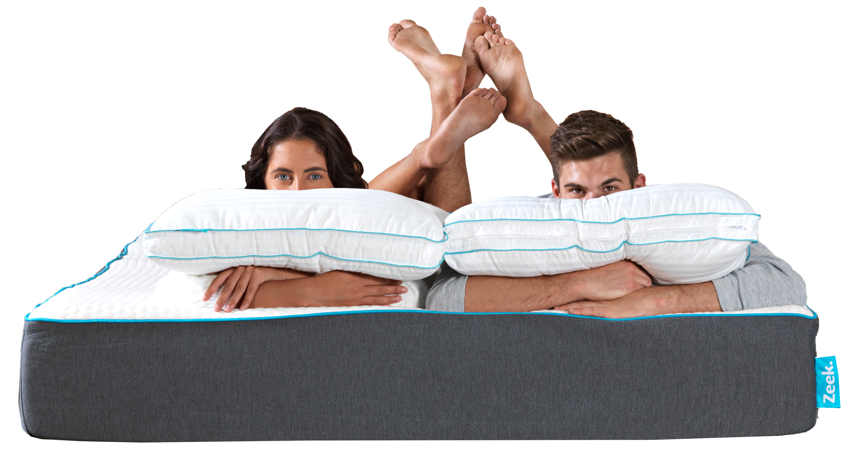 A couple laying on a Zeek mattress with Zeek pillows.