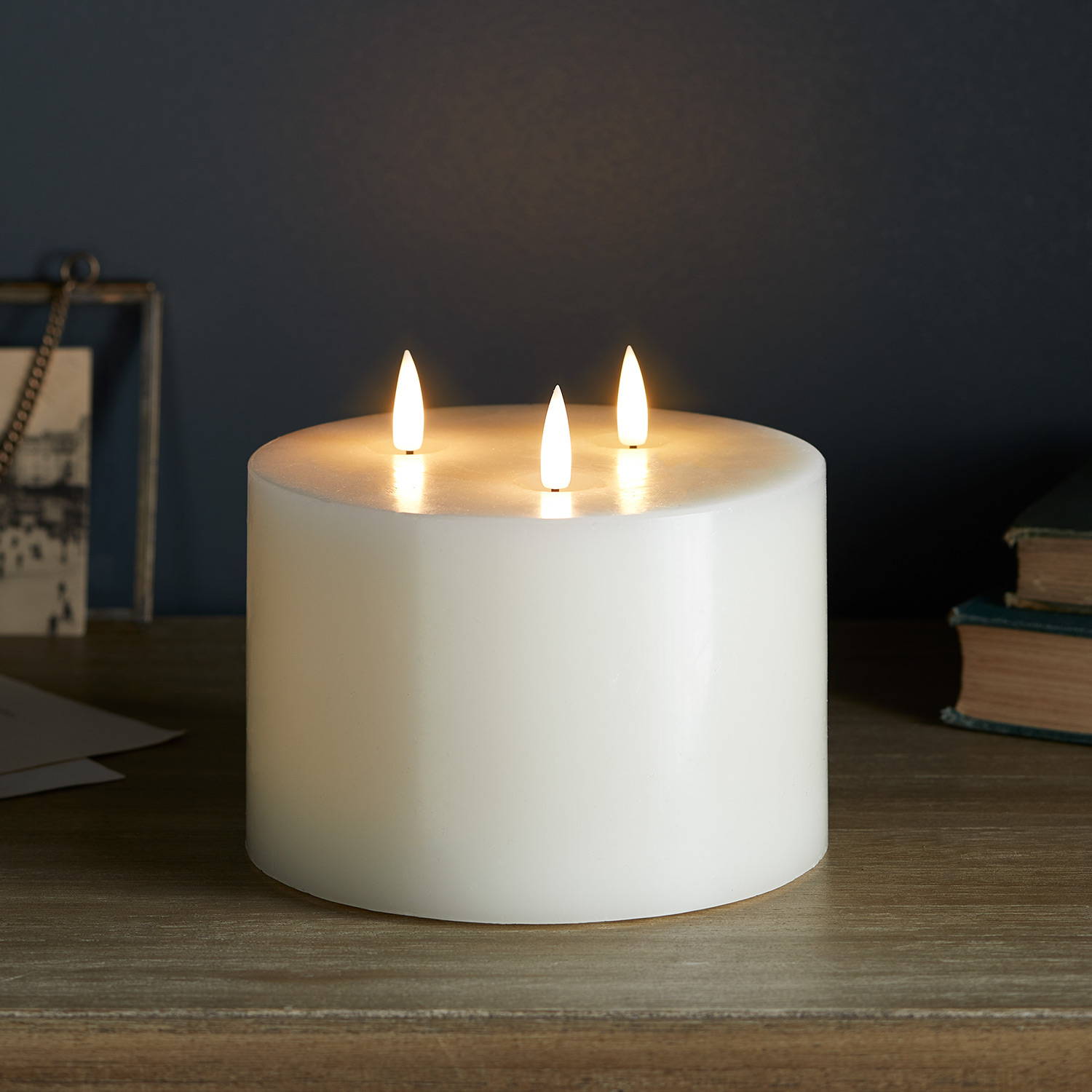 3 wick ivory TruGlow candle illuminated on table