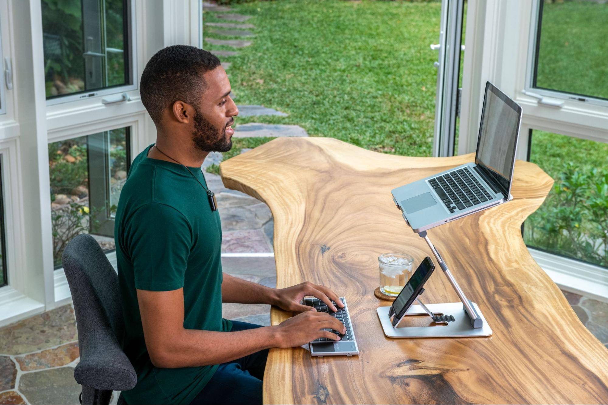 Man with great posture working at desk with laptop on laptop stand