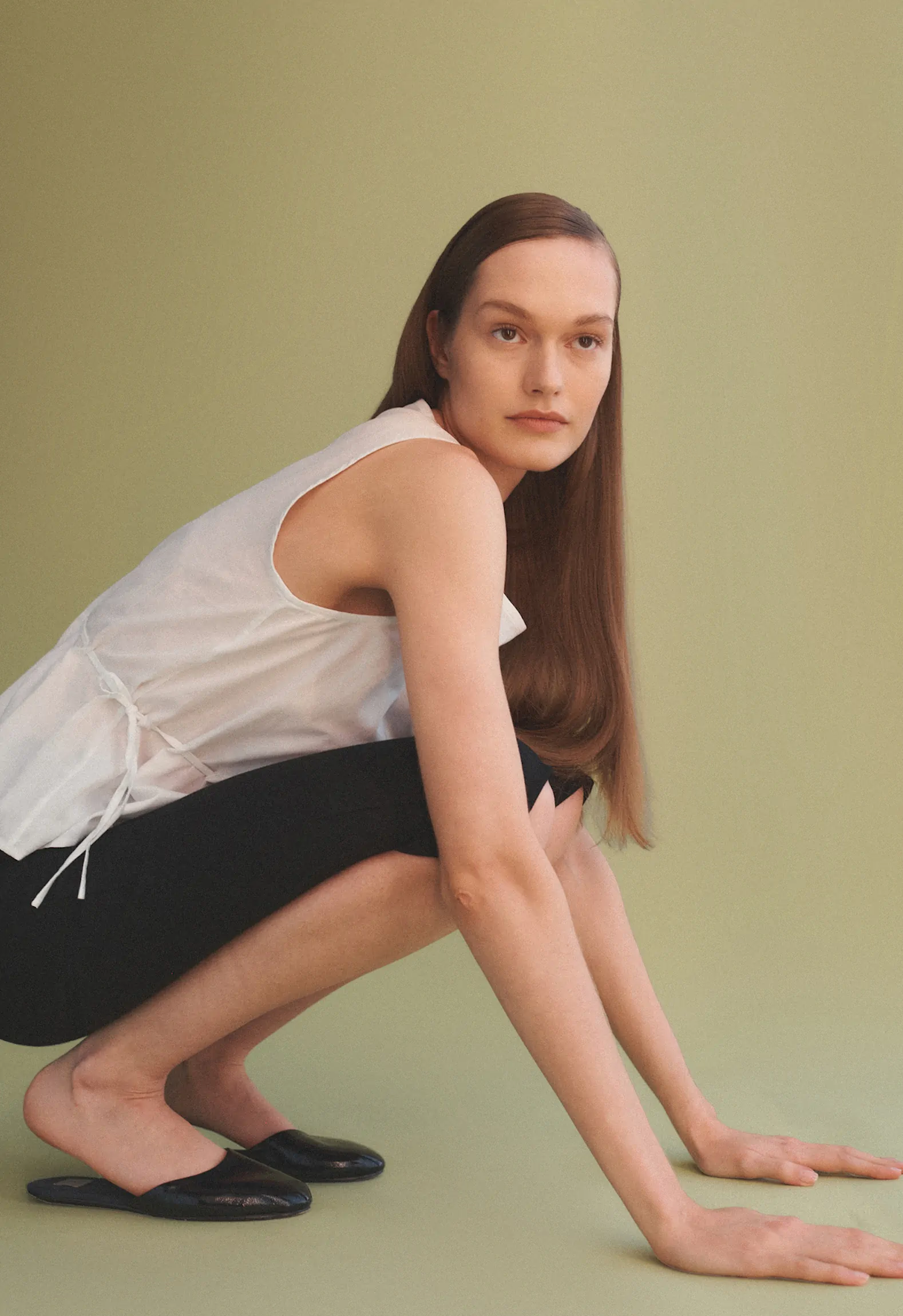 Woman crouched down with hands on ground