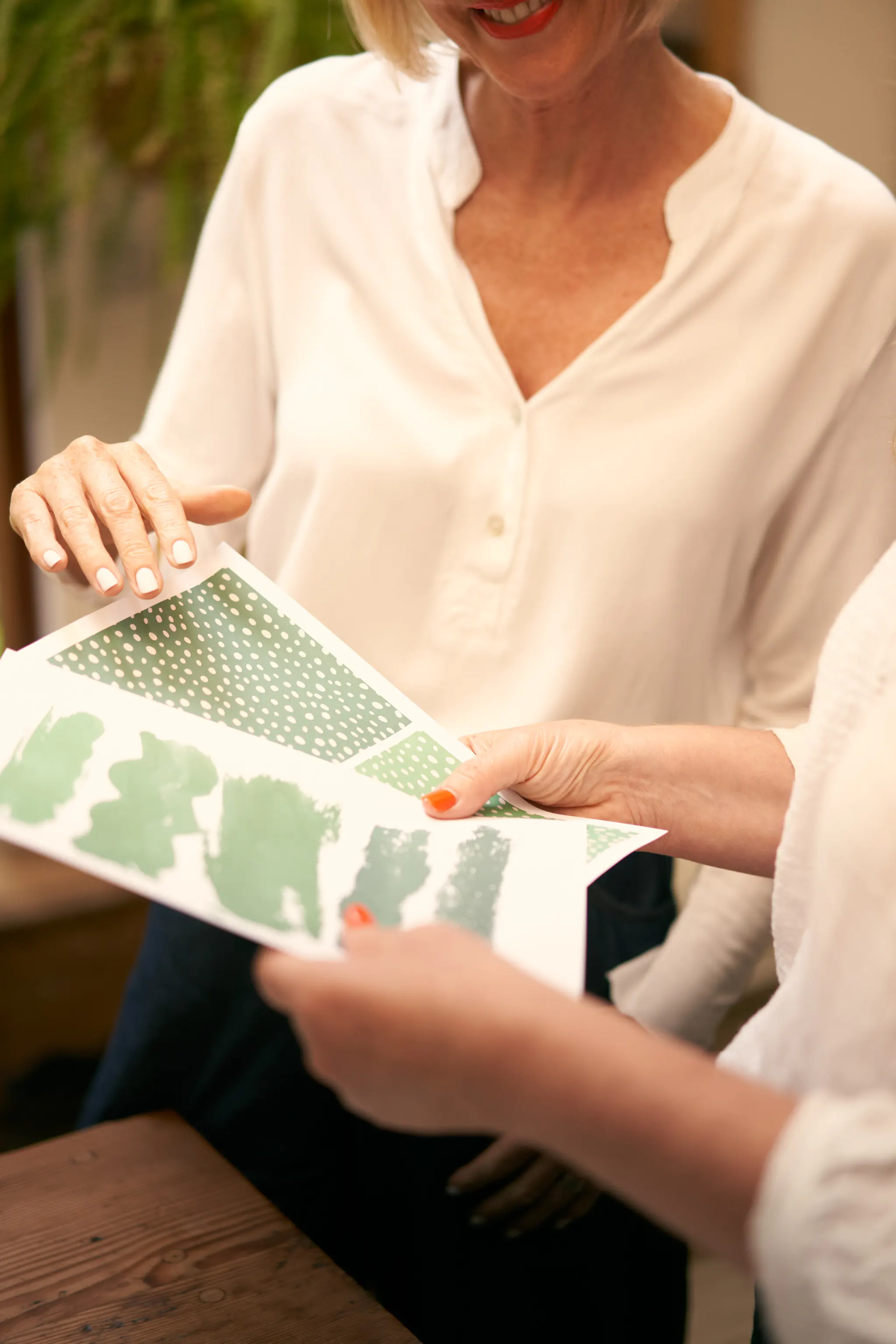 Two woman holding clothing pattern samples