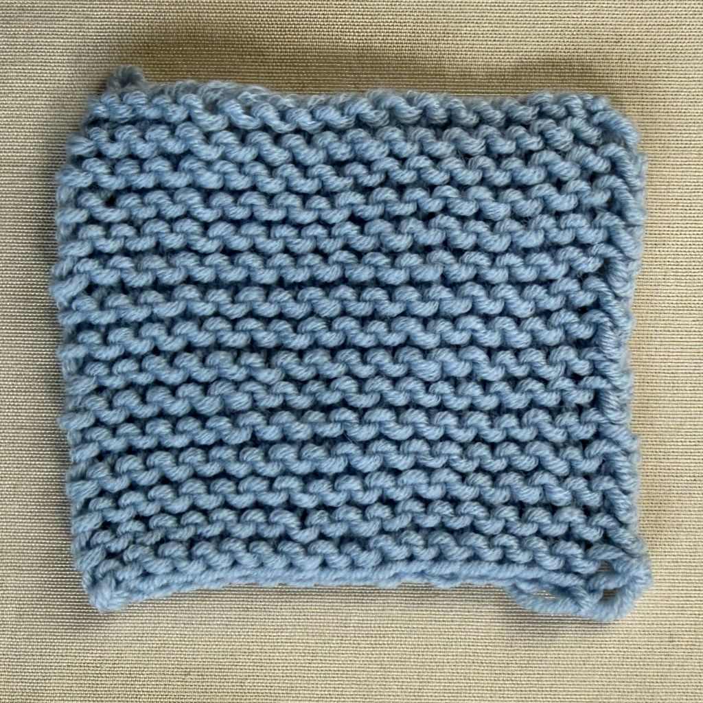 Kraus rechts gestrickte Maschenprobe aus hellblauem Garn