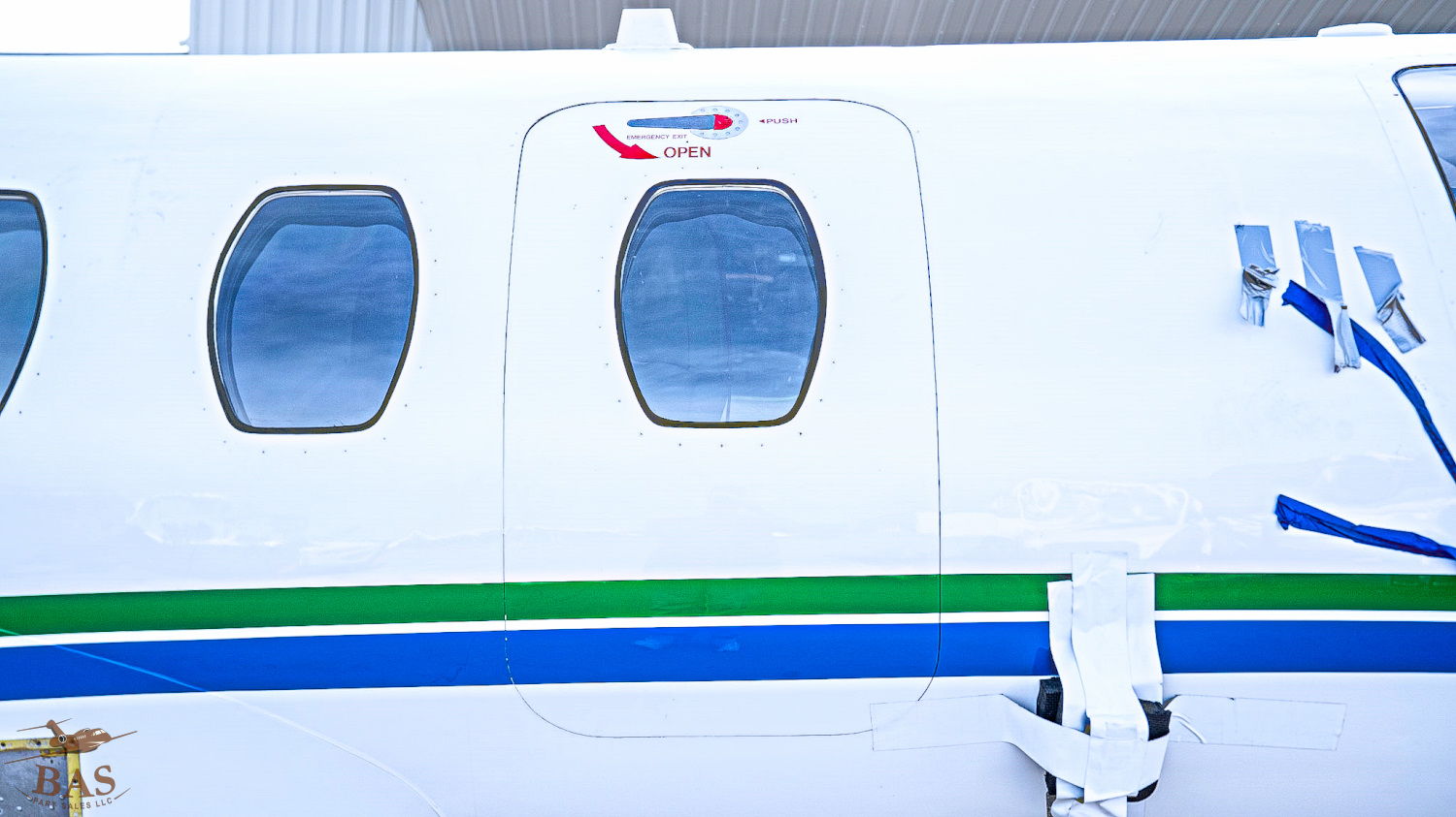 White aircraft with green and blue stripes, featuring multiple windows.
