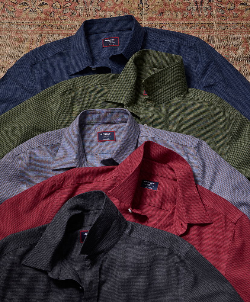 A stack of various colored collared shirts.