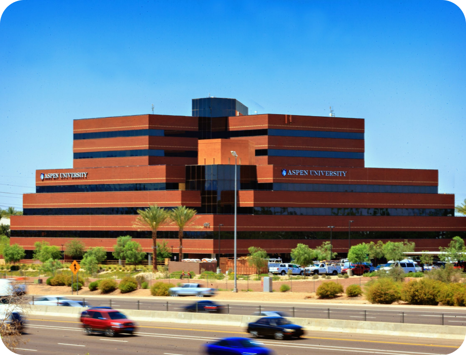 Modern brick office building with clear blue sky and surrounding greenery.