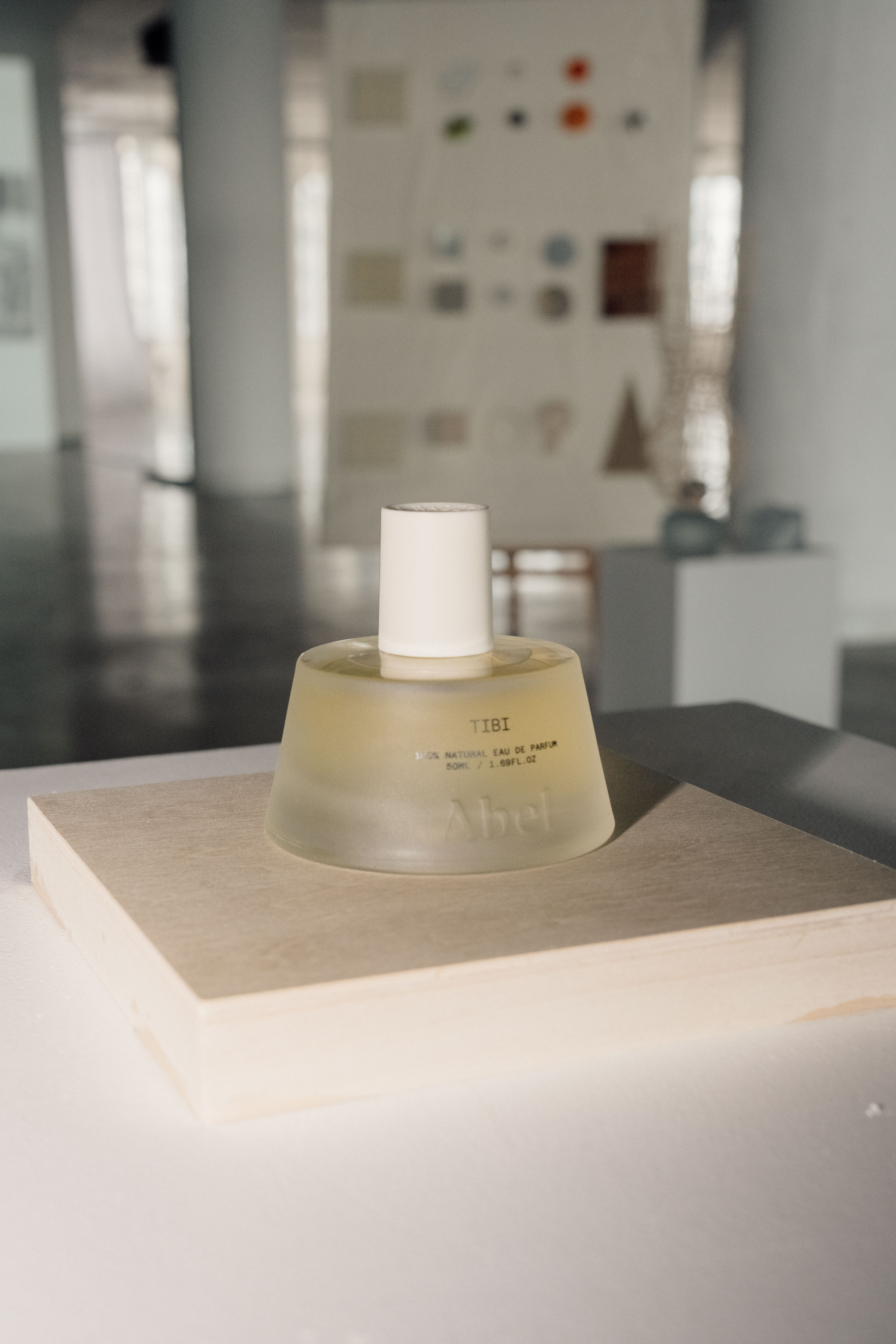 A bottle of perfume on a display in a modern space.