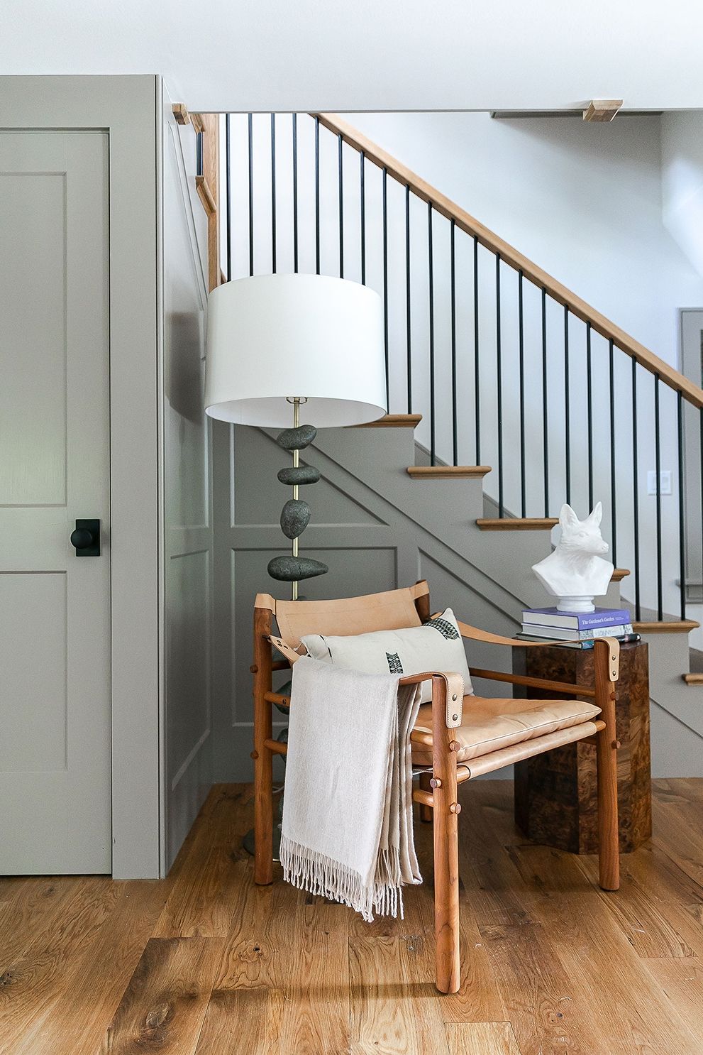 Cozy interior featuring a chair, lamp, and staircase.
