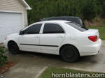 Side profile white 2001 Toyota Corolla sedan black steel wheels tinted windows Nathan AirChime K5LA train horn featured customer install gallery photo 1