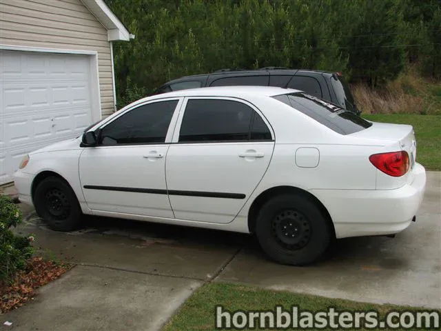 Side profile white 2001 Toyota Corolla sedan black steel wheels tinted windows Nathan AirChime K5LA train horn featured customer install gallery photo 1