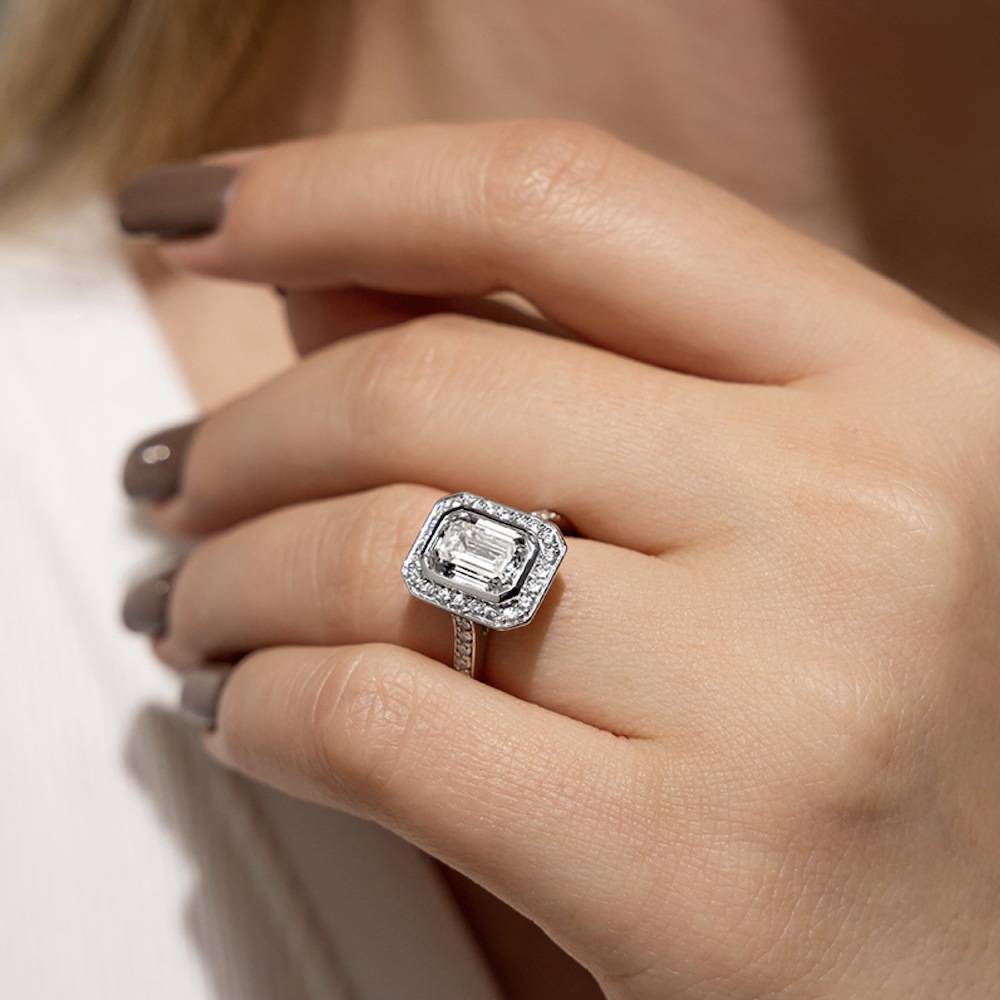 heirloom engagement ring with diamond accents and milgrain detailing holding a 3ct emerald cut lab grown diamond in 14k white gold